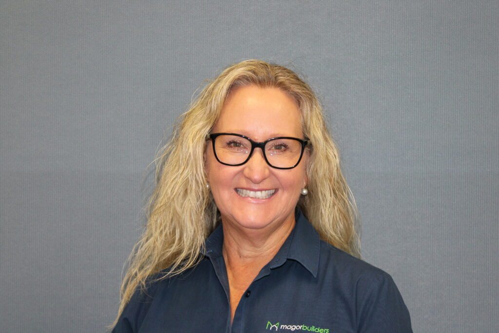 Portrait of Anita of Magor Builders, smiling in a navy Magor Builders shirt.