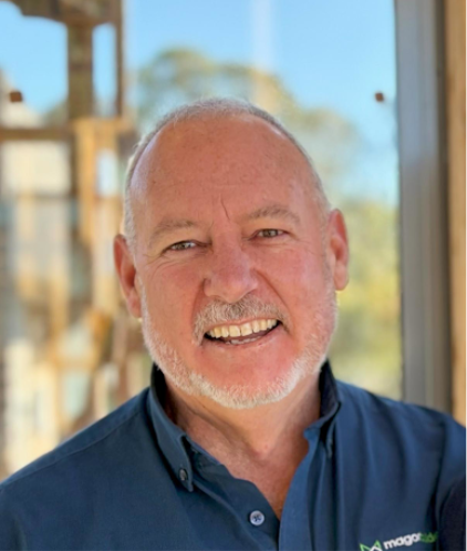 Portrait of Simon Magor of Magor Builders, smiling in a navy Magor Builders polo shirt.
